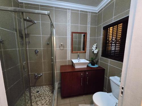 ein Badezimmer mit Dusche, Toilette und Waschbecken in der Unterkunft 16 Cabanas Del Mar Winklespruit KZN South Coast in Kingsborough