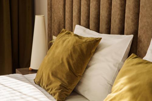 a group of pillows on a bed with a headboard at Port Plaza EVN in Pʼarakʼar