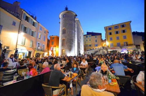 Un grand nombre de personnes assises à des tables dans une rue dans l'établissement Studio Cosy & Zen Hyères centre, à Hyères