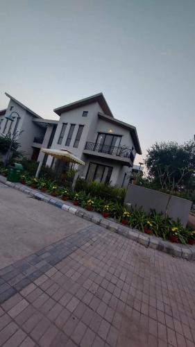 a large white house with a brick driveway at A perfect place to be in nature in Kolkata