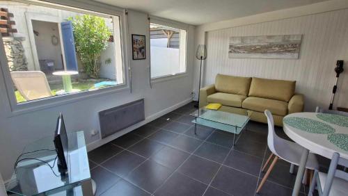 un salon avec un canapé et une table dans l'établissement Gîte le Doux Galet, à Bretteville