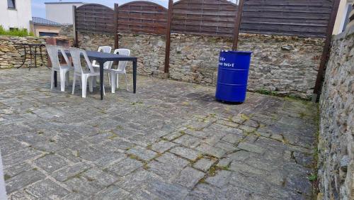 une poubelle bleue assise à côté d'une table et de chaises dans l'établissement Gîte le Doux Galet, à Bretteville