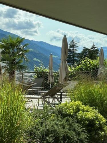 a view of a patio with umbrellas and chairs at Marchegg Apartments in Naturno