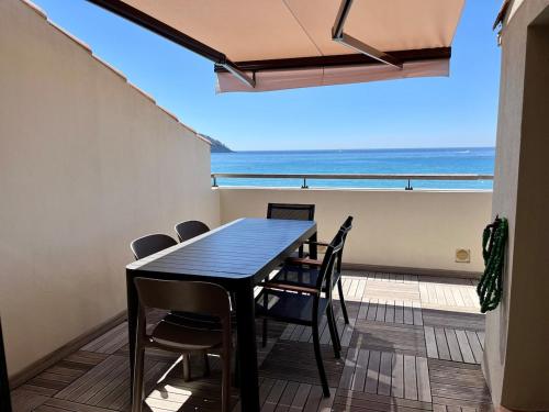 une salle à manger avec une table et des chaises et l'océan dans l'établissement Exceptionnel! ST CYR SUR MER Appartement sur Plage, aux Lecques