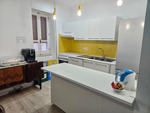 a kitchen with white cabinets and a white counter top at B&B Via Nazionale in Milazzo