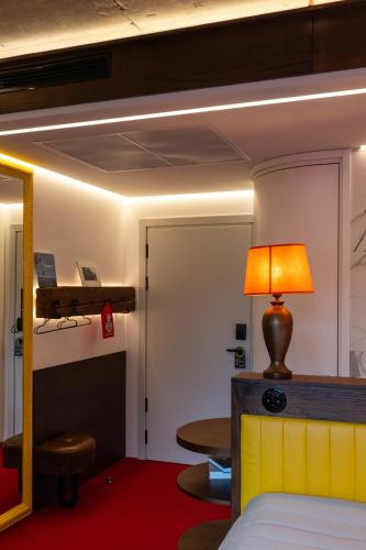 a room with a bed and a table and a mirror at !FEST Hotel Rynok Square in Lviv