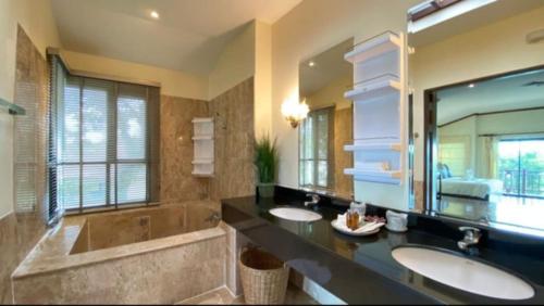 a bathroom with two sinks and a large mirror at Pool Villa Ao Pro in Ban Ao Kung