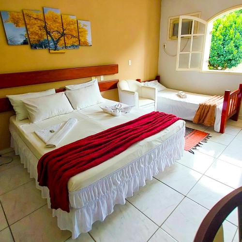 a bedroom with two beds and two windows at Pousada Pouso Alegre in Macuco