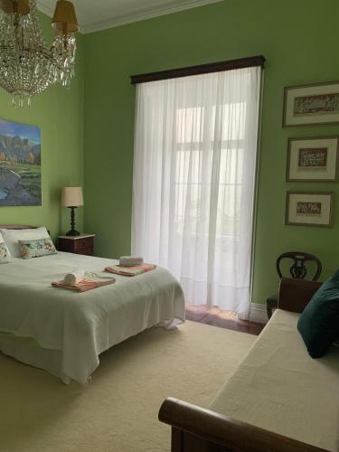 a green bedroom with two beds and a window at Casa de Santa Margarida in Ponta Delgada