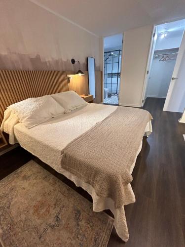 a bedroom with a large bed with a large window at Céntrico Departamento Dúplex a pasos del Metro in Santiago