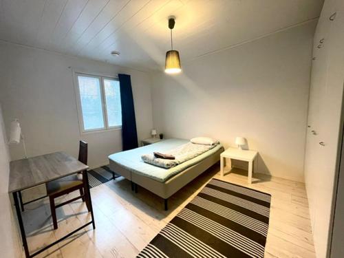 a small bedroom with a bed and a table at Apartment Sorsakuja in Pyhäjoki