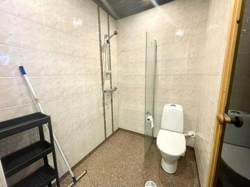 a bathroom with a toilet and a glass door at Apartment Sorsakuja in Pyhäjoki