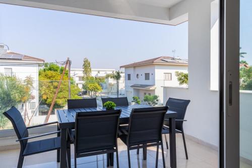 a dining room with a table and chairs on a balcony at Valleria - 2 BR Apartment W Pool in Larnaca in Larnaca