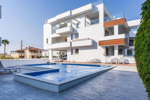 a house with a swimming pool in front of it at Valleria - 2 BR Apartment W Pool in Larnaca in Larnaca