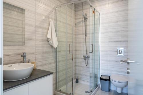 a bathroom with a sink and a glass shower at Valleria - 2 BR Apartment W Pool in Larnaca in Larnaka