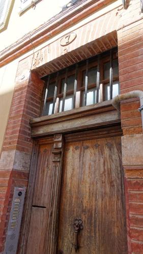 une grande porte en bois sur un bâtiment en briques dans l'établissement Central, charming and peaceful, à Toulouse