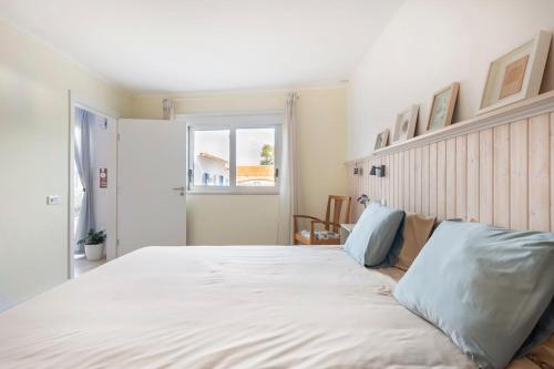 a large white bed in a room with a window at Casa da Annelies. Accessible holiday home in Nadadouro