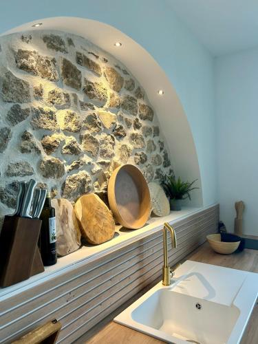 La salle de bains est pourvue d'un mur en pierre et d'un lavabo. dans l'établissement Bali Suite - Spa Jacuzzi, à Saint Etienne