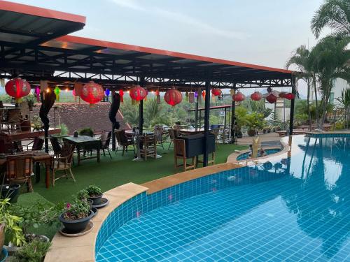 a swimming pool with a table and chairs and a restaurant at Krabi Villa Phu Khao Private Resort in Klong Muang Beach