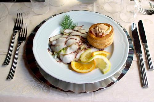 a white plate of food on a table with forks at Park Hotel Valle Clavia in Peschici
