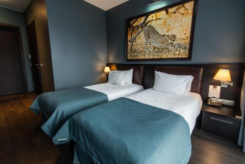 a hotel room with two beds and a painting on the wall at Bartolomeo in Dnipro