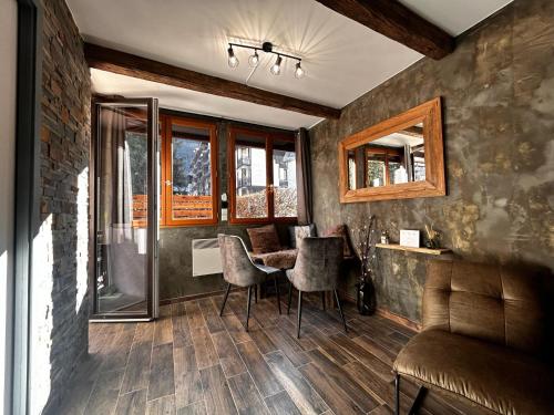un salon avec un canapé, une table et des chaises dans l'établissement Jonquille 2 - Centre - Terrasse Privee - Vues, à Chamonix-Mont-Blanc