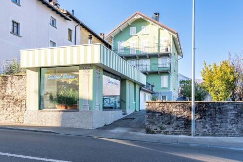 a store on the side of a street with a building at One Only Losone Suite in Losone