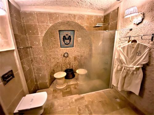 a bathroom with a shower with a sink and a toilet at Mimi Cappadocia Luxury Cave Hotel in Uchisar