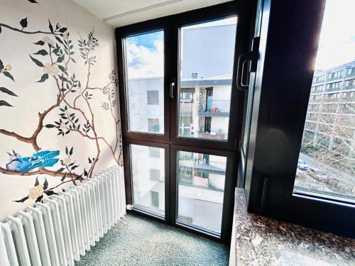 a room with a window and a wall with birds on it at Hotel Erzgiesserei Europe in Munich