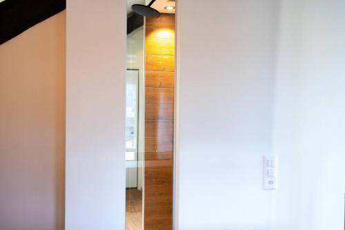 a hallway with a mirror and a wooden wall at One Only Losone Suite in Losone