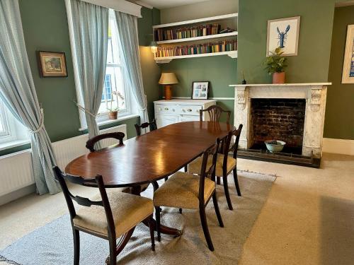 a dining room with a table and chairs and a fireplace at Benson House - Rye Town Centre, East Sussex in Rye