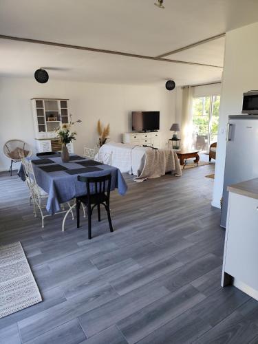 une cuisine et un salon avec une table et un lit dans l'établissement maison dans quartier calme, à Soulac-sur-Mer
