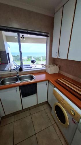 a small kitchen with a sink and a window at 7 Uvongo Breeze in Margate