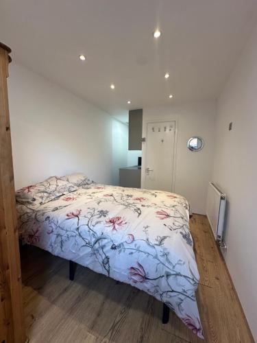 a bedroom with a bed with a floral comforter at Ensuite double Room near ExCeL London in London