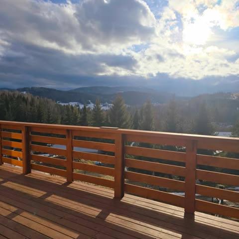 a wooden deck with a view of the mountains at Solna Chata-dom na wyłączność Grota solna, balia, sauna, basen in Rajcza