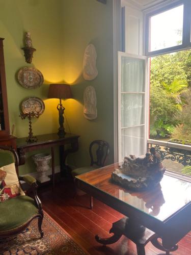 a living room with a table and a window at Casa de Santa Margarida in Ponta Delgada