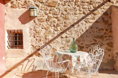 a table with a vase on top of it next to a wall at Casica de Perintín in Ojós
