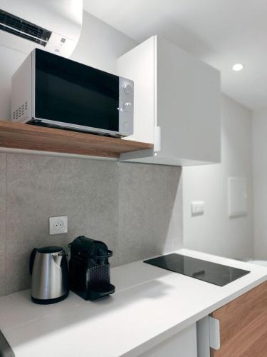une cuisine avec un micro-ondes et un plan de travail dans l'établissement Le Mirabeau studio au cœur du centre historique - 2eme étage, à Aix-en-Provence