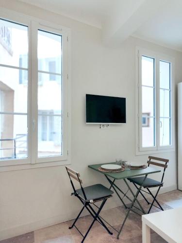 - un salon avec une table, 2 chaises et une télévision dans l'établissement Le Mirabeau studio au cœur du centre historique - 2eme étage, à Aix-en-Provence