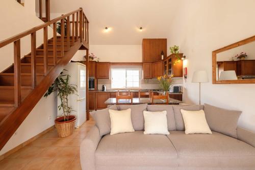 a living room with a couch and a staircase at Casa do Arrozal Comporta in Comporta