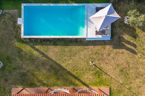 an overhead view of a swimming pool with an umbrella at Casa do Arrozal Comporta in Comporta
