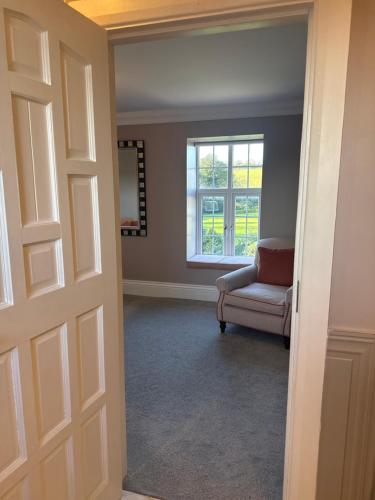 a room with a door and a chair and a window at Ballea Castle in Cork