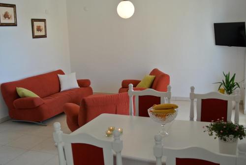 a living room with red chairs and a table at Apartments Topli Bok in Trogir