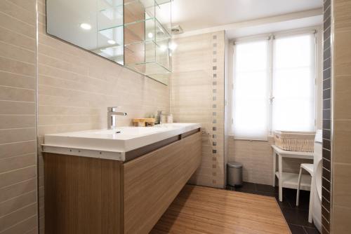 une salle de bain avec un lavabo et un miroir dans l'établissement CIA - Réaumur Étienne Marcel 8P, à Paris