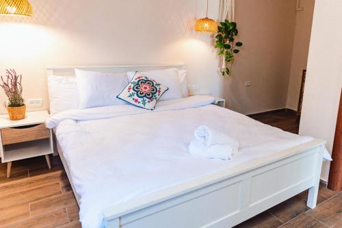 a bedroom with a white bed with a towel on it at שיח מדבר לינה בנגב Burning Bush Negev in Merhav Am