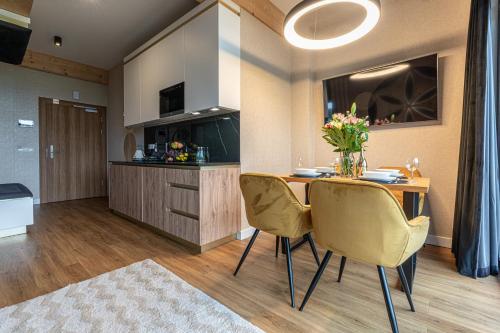a kitchen and dining room with a table and chairs at Aparthotel Tatrzański SPA in Białka Tatrzanska