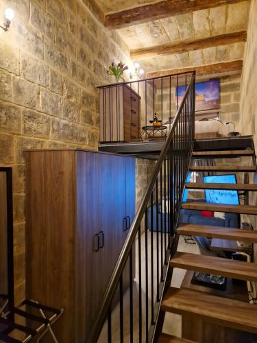 a staircase in a room with a brick wall at Ancient Maltese House with modern interior 3 min away from Airport TAL-PINU in Gudja