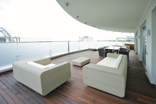 a room with two couches and tables on a balcony at Hotel Premier & Suites - Premier Resort in Milano Marittima