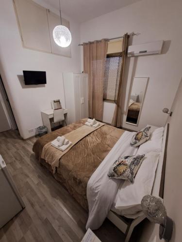 een slaapkamer met een groot bed met handdoeken erop bij Bedroom la stazione in Palermo