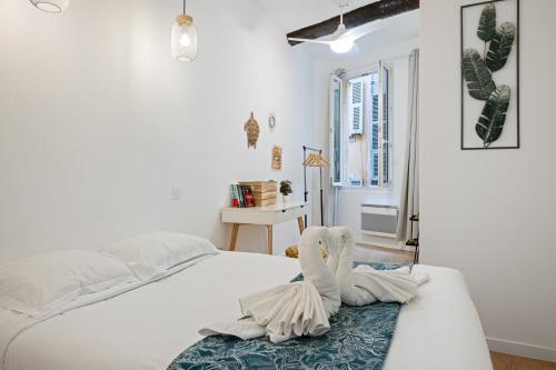 - une chambre avec un lit blanc et une serviette dans l'établissement Le Castelosa - Au coeur du Vieux-Nice, à Nice